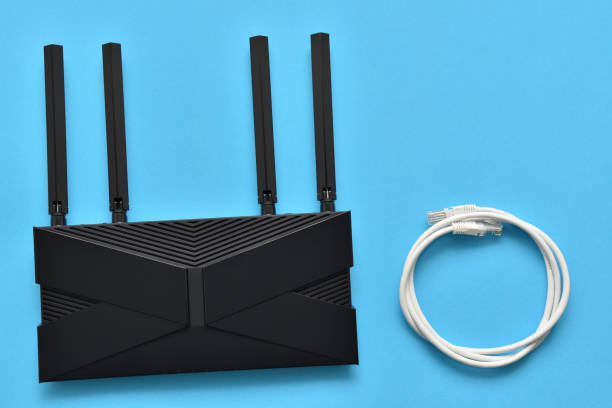istock Modern wi-fi router and ethernet cable for connection on a blue background 1303173953