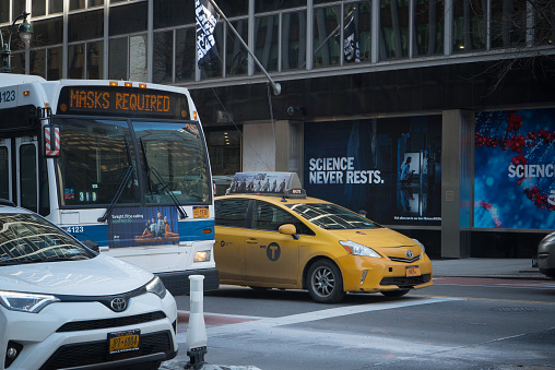 Manhattan, New York, February 17, 2021. A bus and a yellow cab in front of Pfizer headquarters in Midtown.