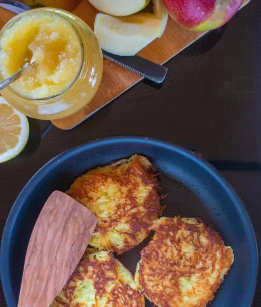 fresh fried potato pancakes with apples sauce served in a pan on a stove