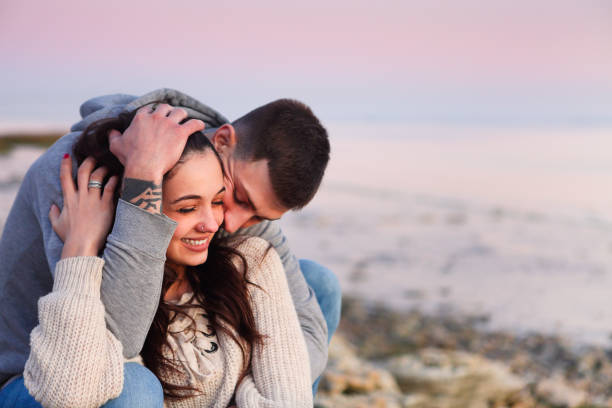 istock Young couple at rocky seacoast in sunset 1303177496