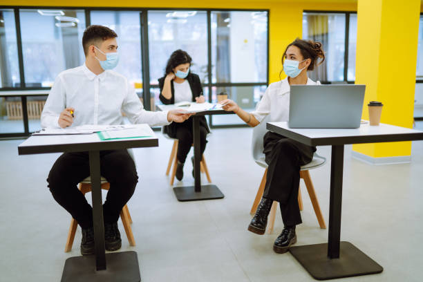 istock Young people with face masks back at work or school in office after lockdown. 1303180255