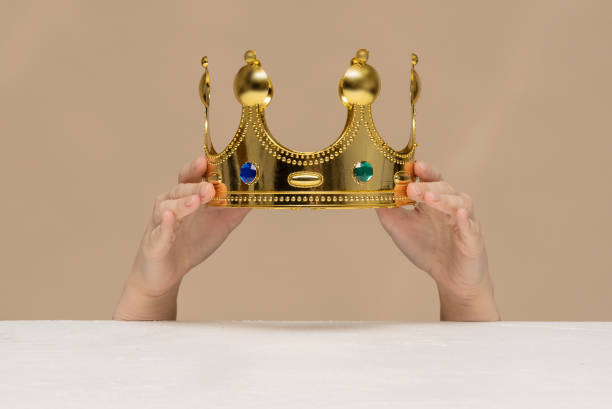 Crown. A golden crown in female hands close up above a table. coronation photos stock pictures, royalty-free photos & images