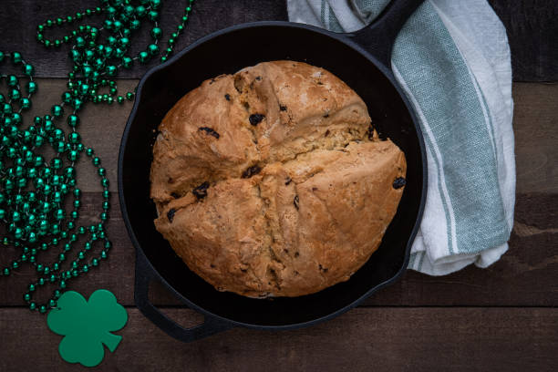 聖パトリックの日のためにシャムロックビーズと鋳鉄のスキレットで焼かれたアイルランドのソーダパン - soda bread bread brown bread loaf of bread ストックフォトと画像