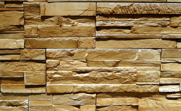 istock Rustic yellowish brown stone wall made of irregular horizontal natural rocks. Paneling. 1303183928
