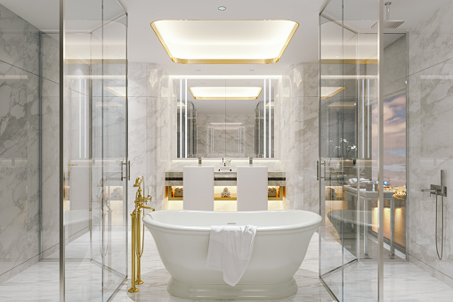 A glam white bathroom done with white luxurious marble tiles and golden details.