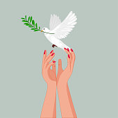 istock Holding peace dove with olive branch in her slender hands . 1303188726