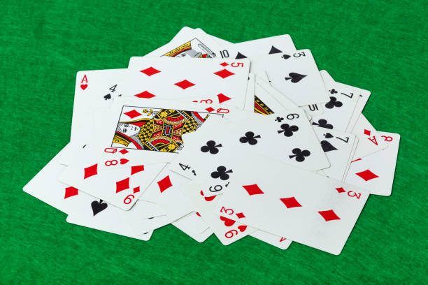 istock Casino playing cards on green table 1303189920