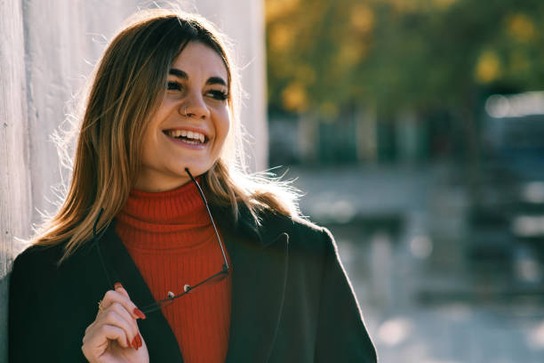 istock Woman smiling while standing outdoors on the street. 1303190690