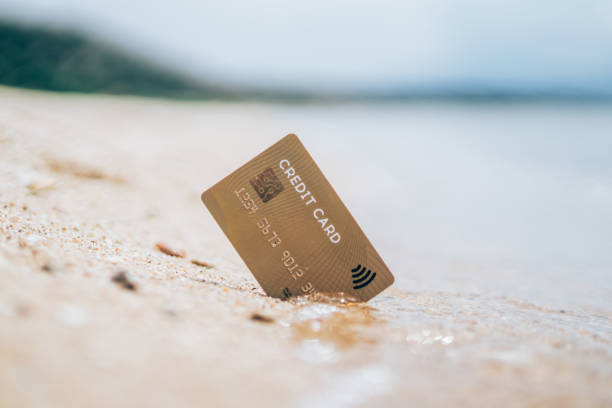 istock Credit card in the sand on the beach 1303194055