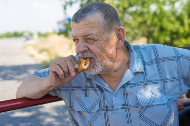 istock ungry senior driver eating patty filled with fried cabbage while short  stop 1303194317