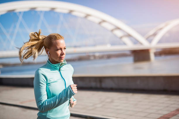 istock Determined mid adult woman running. 1303197339