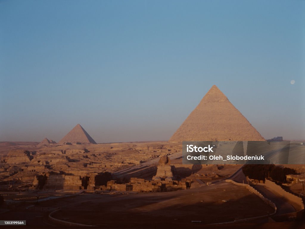 Scenic view of Giza pyramids at sunset Scenic view of Giza pyramids at sunset. Medium format camera Archival Stock Photo
