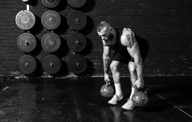 istock Young active strong sweaty fit muscular man with big muscles doing back muscles workout with kettlebells in the gym as hardcore cross training real people exercise 1303200311