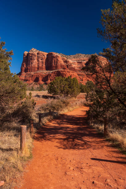 A dirt footpath leading to Courthouse Rock, a red sandstone rock formation found in Sedona, Arizona.
