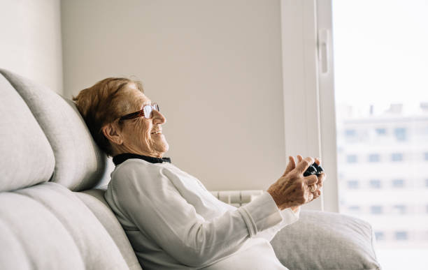 istock Content elderly woman with console playing video game 1303201784