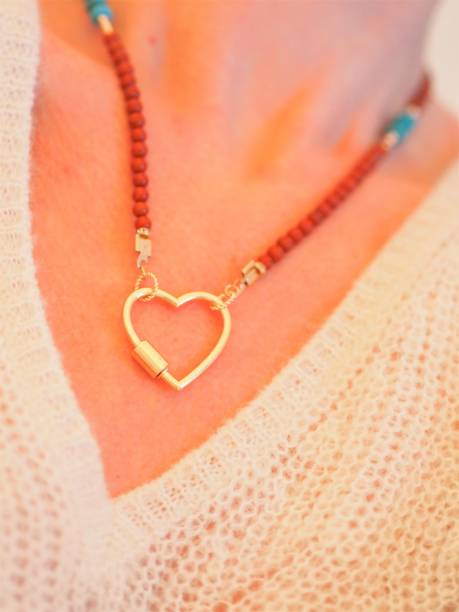 collar heartshape y jersey blanco en una mujer - heart pendant fotografías e imágenes de stock