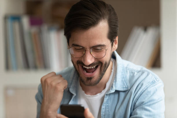 istock Overjoyed man look at cellphone screen triumph winning lottery 1303206531