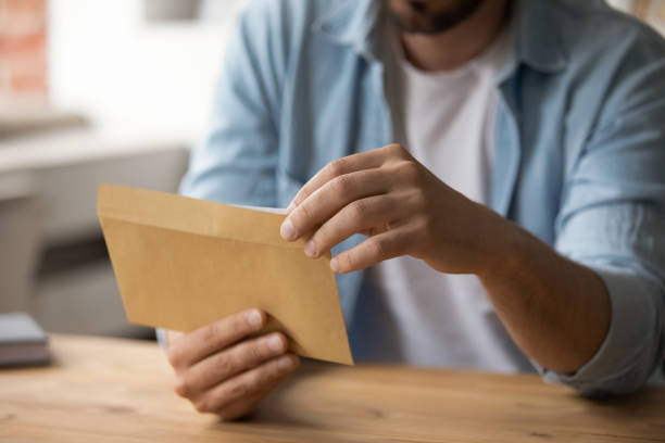 istock Close up of male employee open envelope with letter 1303206557