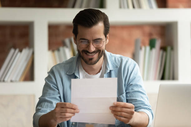 istock Happy young man read good news in postal letter 1303206567