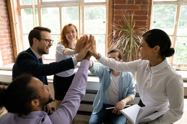 istock Excited multiethnic colleagues engaged in teambuilding activity at meeting 1303206622