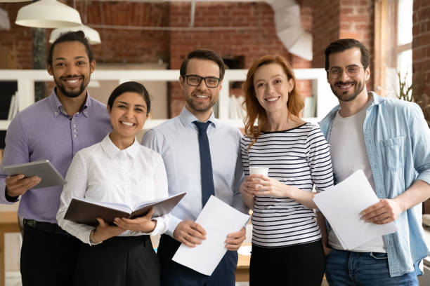 istock Portrait of smiling multiethnic colleagues pose in office 1303206637