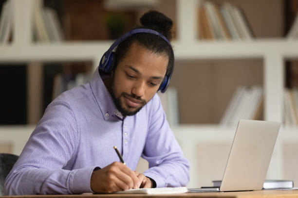 istock African American man in headphones study online on computer 1303206683