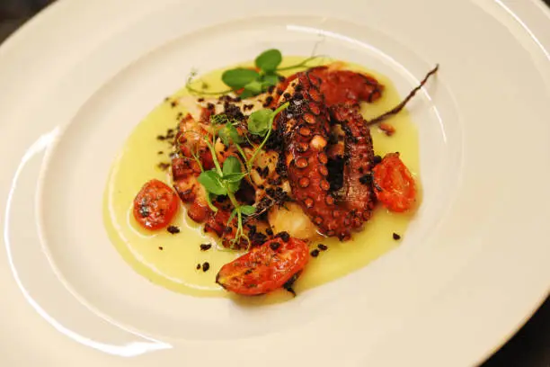 Typical Italian dish: octopus with chickpea cream and cherry tomatoes