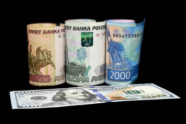 istock Russian rubles and American dollar bills. Russian ruble is going down or growing up. 1303206979