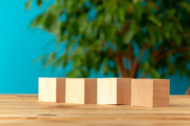 istock Wooden blocks on desk against blurred plant background 1303208956