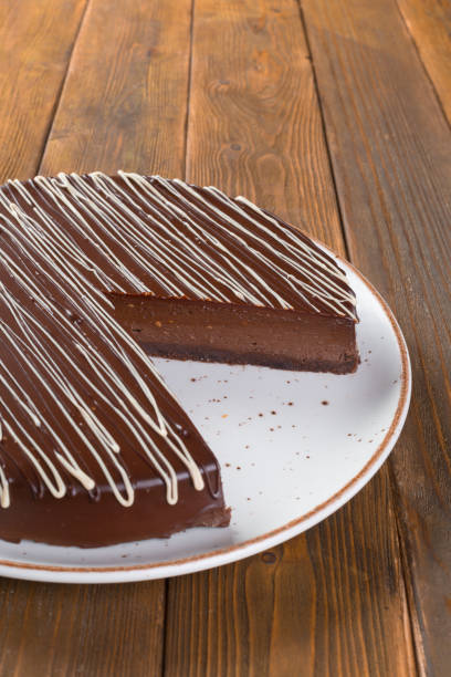 istock Cut chocolate cake on plate on wooden table 1303208987