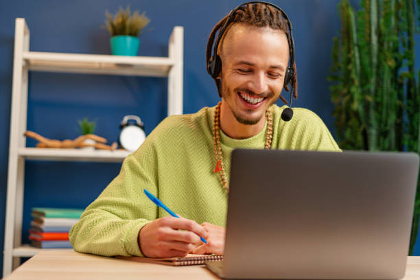 istock Young man with headset looking at laptop camera. Service consultant concept 1303209035