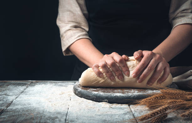 istock A woman kneads dough on a dark vintage background 1303209198