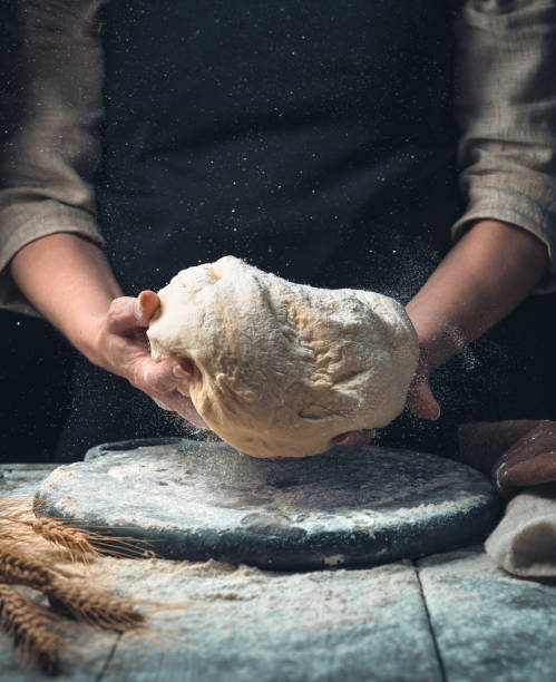 istock Dough and cook among flour and small dust particles on a dark background 1303209824