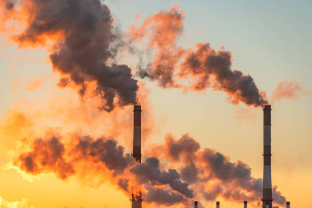 istock Emissions from factories chimneys producing smoke at sunrise 1303210234