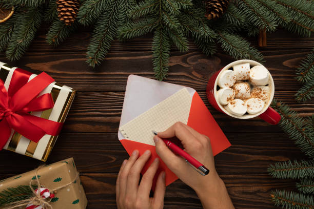 un homme écrit une lettre au père noël avec des souhaits pour noël. - pencil pine photos et images de collection