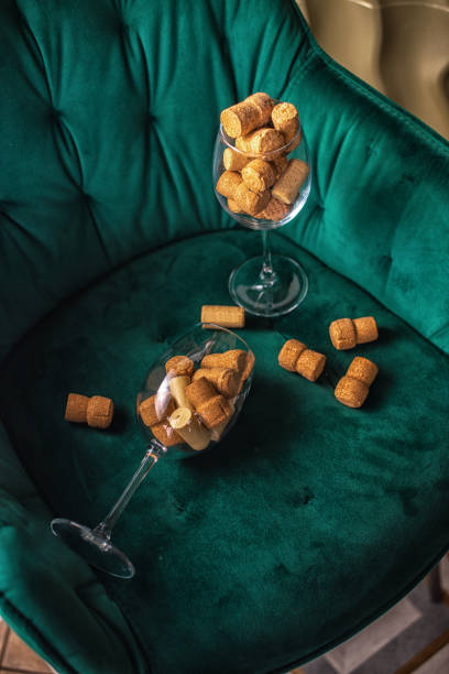 Wine corks in glass on green armchair Wine corks in glass on green armchair cork puller stock pictures, royalty-free photos & images