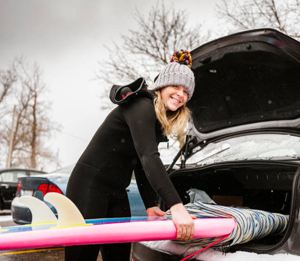 istock Young woman getting ready to surf in winter 1303214805