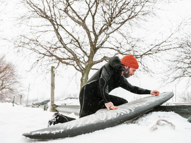 istock Young man getting ready to surf in winter 1303214905
