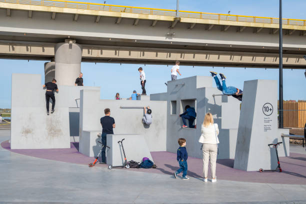 erwachsene und kinder trainieren in der parkour zone - skateboard court stock-fotos und bilder