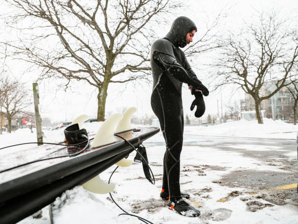 istock Young man getting ready to surf in winter 1303215006