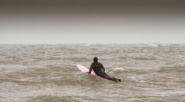 istock Young woman during winter surf 1303215107