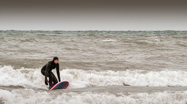 istock Young woman during winter surf 1303215121