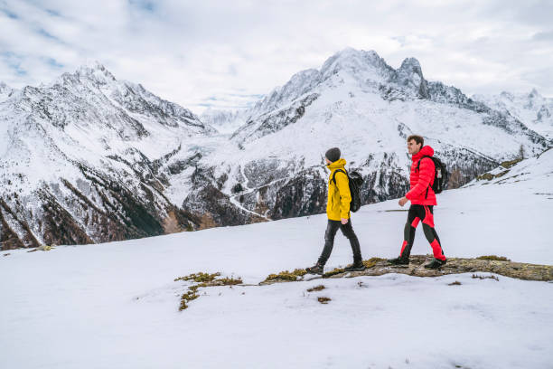 istock Hikers explore snowy ridge in mountains 1303215989
