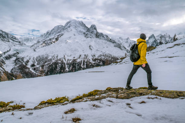 istock Hiker walks along a snowy mountain ridge 1303216154