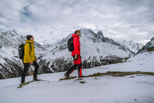 istock Hikers explore snowy ridge in mountains 1303216185