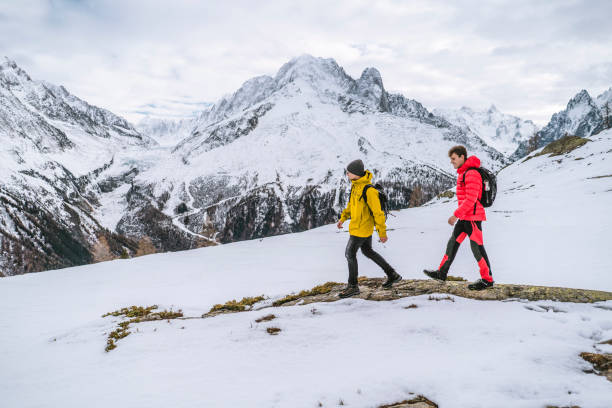istock Hikers explore snowy ridge in mountains 1303217882