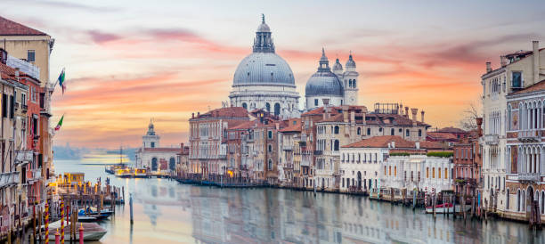 Stunning view of the Venice skyline with the Grand Canal and Basilica Santa Maria Della Salute in the distance during a dramatic sunrise. Picture taken from Ponte Dell’ Accademia. Stunning view of the Venice skyline with the Grand Canal and Basilica Santa Maria Della Salute in the distance during a dramatic sunrise. Picture taken from Ponte Dell’ Accademia. cruise ship photos stock pictures, royalty-free photos & images