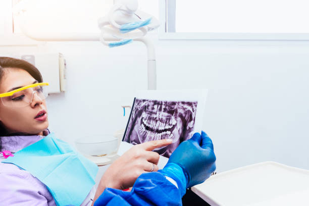 dorosłej kobiety w klinice stomatologicznej wskazującej na ustną rtg koncepcji higieny jamy ustnej i zdrowia. - pacient zdjęcia i obrazy z banku zdjęć