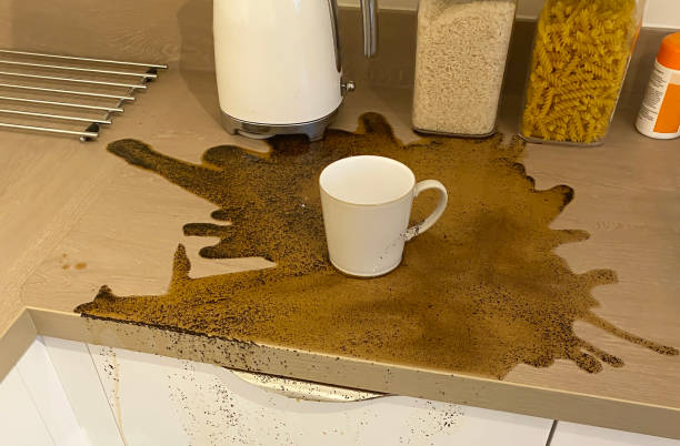 istock Spilt coffee drink and ground beans on kitchen worktop 1303223921