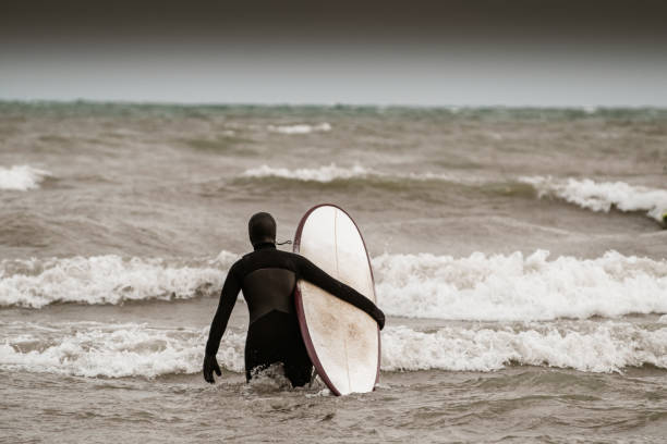 istock Young woman during winter surf 1303223922